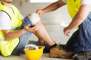 Worker With Bandaged Knee Wearing Work Clothes