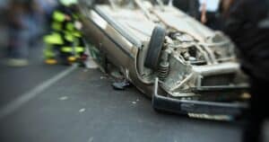 Emergency workers attempt to assist injured people following a roll over crash