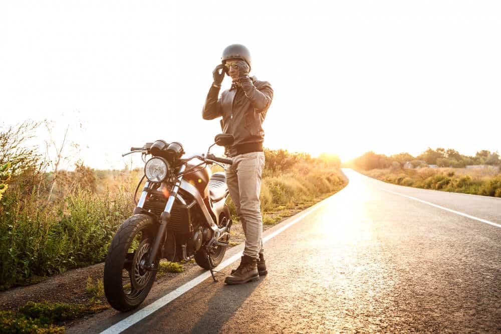 Man Wearing Helmet on the Side of the Road