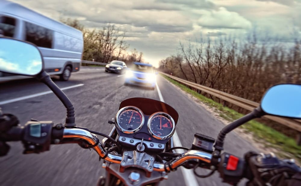 Motorcycle In Front Of A Light Vehicle